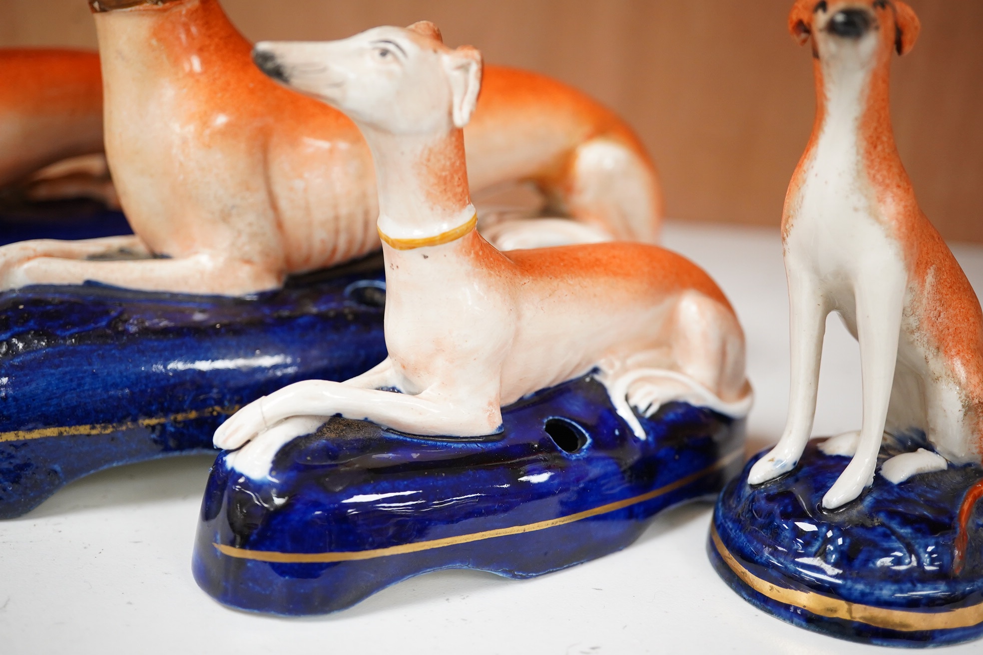 Three graduated Staffordshire pottery greyhounds and two others, longest 19cm (5). Condition - restored